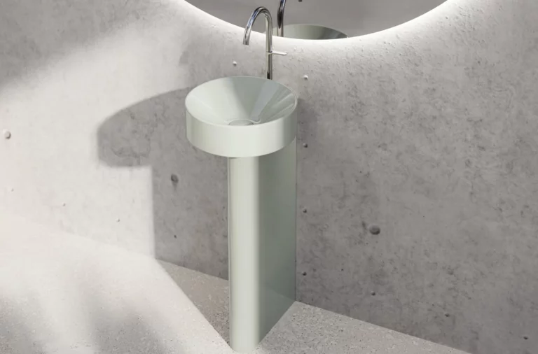 Rundes Stahl-Email Waschbecken mit zylindrischem Standfuß vor Betonwand, moderner Wasserhahn, kein Waschtisch Einbauplatte.